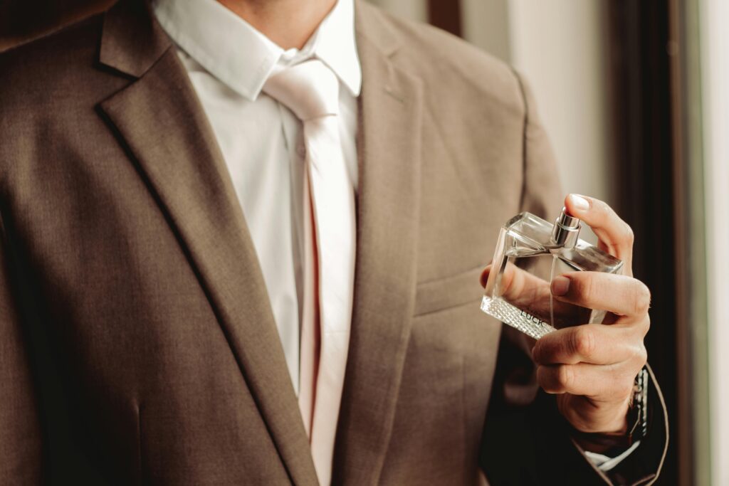 Man Wearing Suit and Necktie with Perfume Bottle. Grooming routine